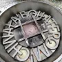 Weathered metal lettering embedded in the Warsaw Uprising Monument pavement