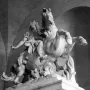 Equestrian Statue of Louis XIV shown as a marble rider on a rearing horse beneath a dark arched ceiling.