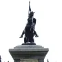 El Cid sculpture of a rider on a rearing horse atop a tiered stone pedestal.