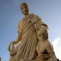 Canapone sculpture with a standing bearded man in classical robes, a seated woman with a baby, and a child at his side.