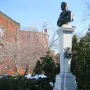 La mort de Dante monument with a dark bust on a tall stone pillar in a snowy park