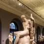 Theseus and the Minotaur marble sculpture showing a nude man seated over a defeated bull-headed creature