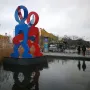 Keith Haring\'s The Boxers sculpture with two brightly colored figures standing in a shallow pool at Potsdamer Platz, Berlin.