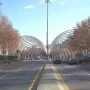 Puerta de la Ilustración spans a Madrid avenue with curved metallic arches over the road and a tall central light pole.