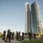 Agora sculptures on a green lawn with Chicago skyscrapers in the background.