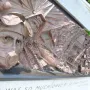 Bronze relief panel on the Battle of Britain Monument showing a pilot in goggles and a gas mask beside scenes of destruction.