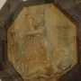 Creation of Eve terracotta relief showing two figures embracing within a dark octagonal frame.