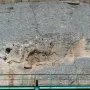 Madara Rider rock relief carved into a weathered cliff face, showing a mounted figure above a faint lion carving.