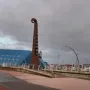 The Blackpool High Tide Organ sculpture beside a blue building on a paved promenade.