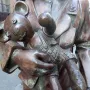 Bronze figure in Trains to Life – Trains to Death holding a stitched toy bear
