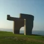 Elogio del Horizonte concrete sculpture on a grassy hill overlooking the sea