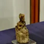 Khufu statuette showing a seated figure wearing a tall rectangular headdress on a clear base.