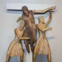 Wooden Descent from the Cross sculpture with a central figure being lowered from a beam by two robed figures, flanked by two crucified figures.