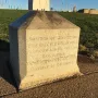 Jefferson Pier stone monument with carved lettering on a paved area near grass.