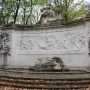 Monument to the Belgian Pioneers in Congo with a curved stone frieze and sculpted figures above a shallow pool