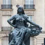 Africa by Eugène Delaplanche, a dark patinated seated woman with a headscarf, flowing drapery, and a basket of fruit, resting her feet on a tortoise.