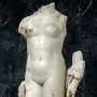 Venus Unica, a headless white stone female nude statue on a rectangular base.