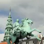 Absalon Monument, a green equestrian statue on a stone pedestal with a tall spire in the background.