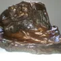 Illusions Received by the Earth, a dark bronze sculpture of two intertwined nude bodies melting into a rocky base.