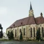 Matthias Corvinus Monument with a bronze equestrian statue and accompanying bronze figures in front of a stone church.
