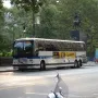 Simón Bolívar Equestrian Statue partially obscured by a large bus in front of trees.