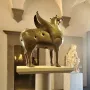 Bronze Pisa Griffin statue on a pedestal in a museum gallery.