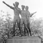 Youth Monument showing three young figures on a stone pedestal, with one male figure saluting and a female figure holding a lute-like instrument.
