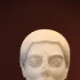 Sabouroff Head marble bust of a male figure with textured hair, mustache, and beard on a stand.