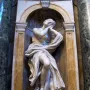 Saints Jerome and Mary Magdalen in white marble, shown in an ornate arched niche with the figure in a contemplative pose.