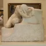 Desolation, a white marble sculpture of a nude kneeling figure with bowed head and long hair draped over the face.