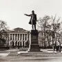 Pushkin statue stands before the Mikhailovsky Palace with a classical facade and trees in the background.