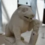Close-up of the Bear of Porcuna stone sculpture, showing a carved animal head beside a smaller human head.