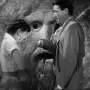 Bocca della Verità stone mask with a man placing his hand in the mouth beside a woman covering her face