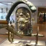 Monteleone Chariot bronze chariot with relief decorations and a stylized face on display in a museum