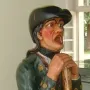 Aschaffenburger Maulaff, a painted wooden figure in a green coat and dark cap, leaning on a staff with its mouth open.
