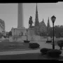 Lafayette Monument with a dark equestrian statue on a stone pedestal, a tall cylindrical monument behind it, and churches and buildings around the plaza.