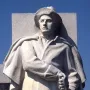 Soldiers\' Monument stone statue of a man in a wide-brimmed hat and long coat holding a sword or rifle hilt.