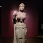Didarganj Yakshi standing stone statue holding a fly-whisk, with necklaces, a headdress, and a draped lower garment.