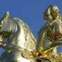 The Golden Rider equestrian statue in Dresden, showing a gilded man on a rearing horse against a blue sky.