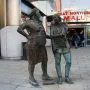 Monument to the Unknown Woman Worker with two weathered bronze female figures, one holding a basket and the other incorporating a rotary phone and keyboard.