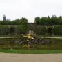 The Enceladus Fountain shows a golden reclining figure emerging from dark rocks in a formal garden pond.