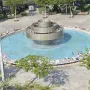 Top-down view of the Fire and Water Fountain with a circular basin, a tiered central structure, and small jets spraying water.