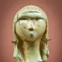 Venus of Brassempouy carved head with a textured cap and cracked surface