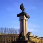 Monument to Vittorio Emanuele II with a bronze statue atop a fluted column and sculpted figures at the base.