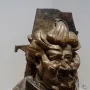 L\'antigrazioso, a bronze-toned abstract bust with angular fragmented forms and a distorted face.