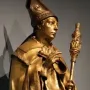 Golden statue of Saint Louis of Toulouse in a carved stone niche with columns and a shell-shaped arch.