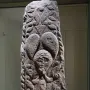 Pfalzfeld Obelisk with carved foliage patterns and three human faces on a stone column.