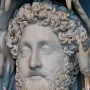 Close-up of the marble bust of Commodus as Hercules with a curly beard and lion skin draped over the shoulders.