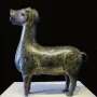 Stylized metallic deer sculpture from Madinat al Zahra on a white pedestal.